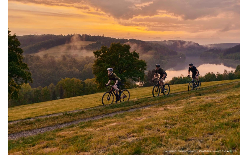 Three gravel bikers on the road in the Bike Arena Sauerland on the Hennesee.