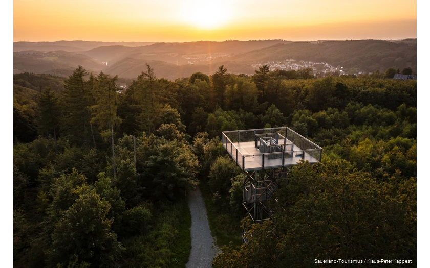 View of the tower from above. The sun is setting in the background and you can see various villages