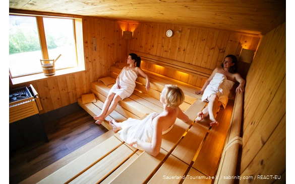 Drie vrouwen ontspannen in een sauna.
