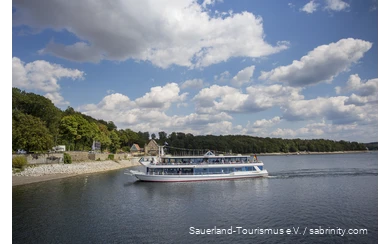 Möhnseeschifffahrt Der Möhnesee an einem Sommertag mit einem Personenschiff voller Menschen im Zentrum