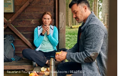 Ein Pärchen macht Pause in einer Schutzhütte am Fernwanderweg Rothaarsteig.