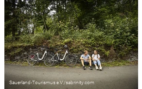 Een paar fietsers nemen een pauze langs de kant van de weg.