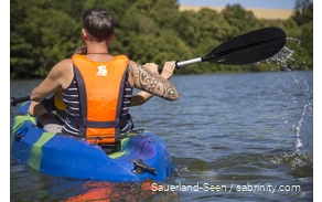 Mann und ein Kind fahren Kanu