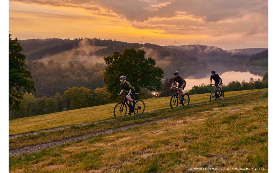 Three gravel bikers on the road in the Bike Arena Sauerland on the Hennesee.