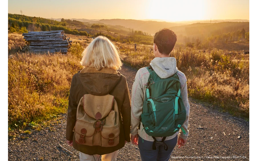 Two female hikers on the Sauerland-Waldroute at sunset.