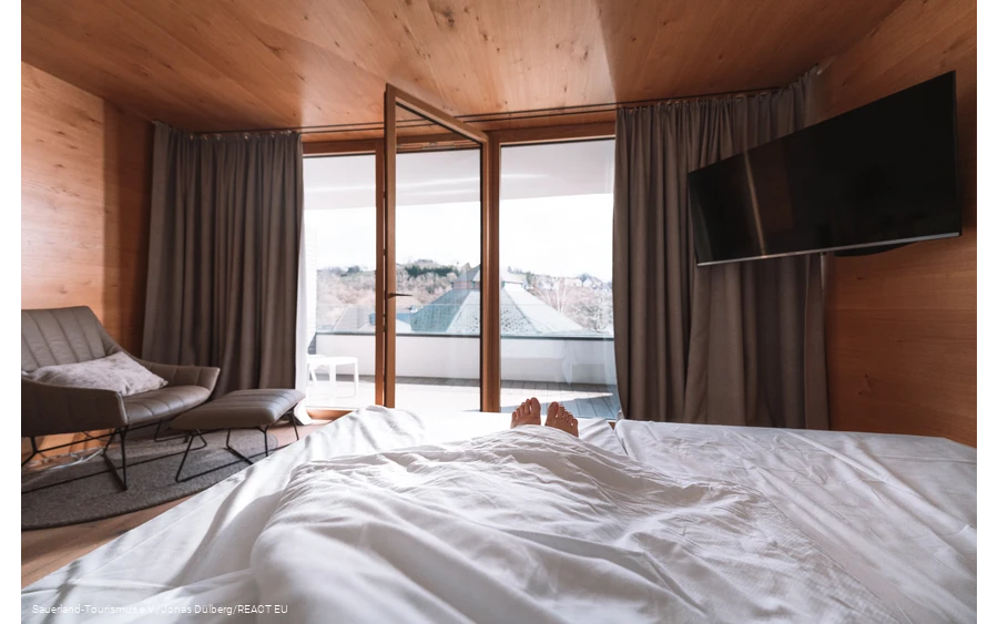 Alleen de voeten kijken uit een bed met een open raam