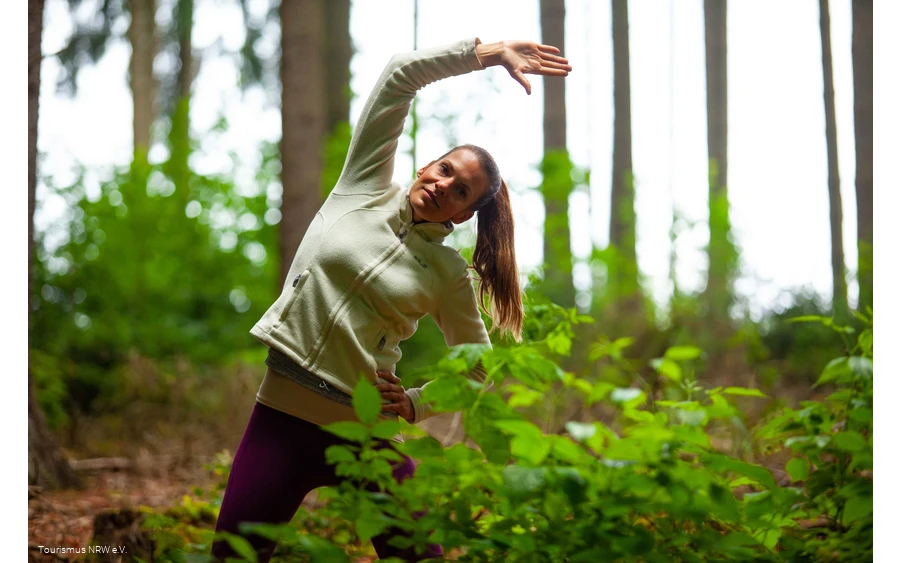 A woman does an exercise in the forest