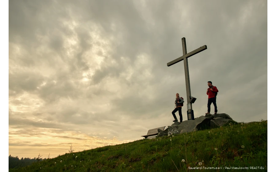 Zwei Wanderer genießen den Sonnenuntergang auf dem Clemensberg.