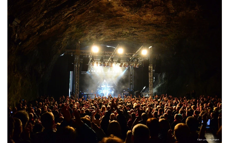 Balver Höhle 2 Concert in de Dechenhöhle met veel bezoekers die naar de muziek op het podium luisteren.