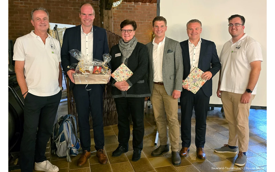Gruppenfoto von ehemaligen Vorstandsmitgliedern des Sauerland-Tourismus mit Präsenten und den beiden Geschäftsführern.