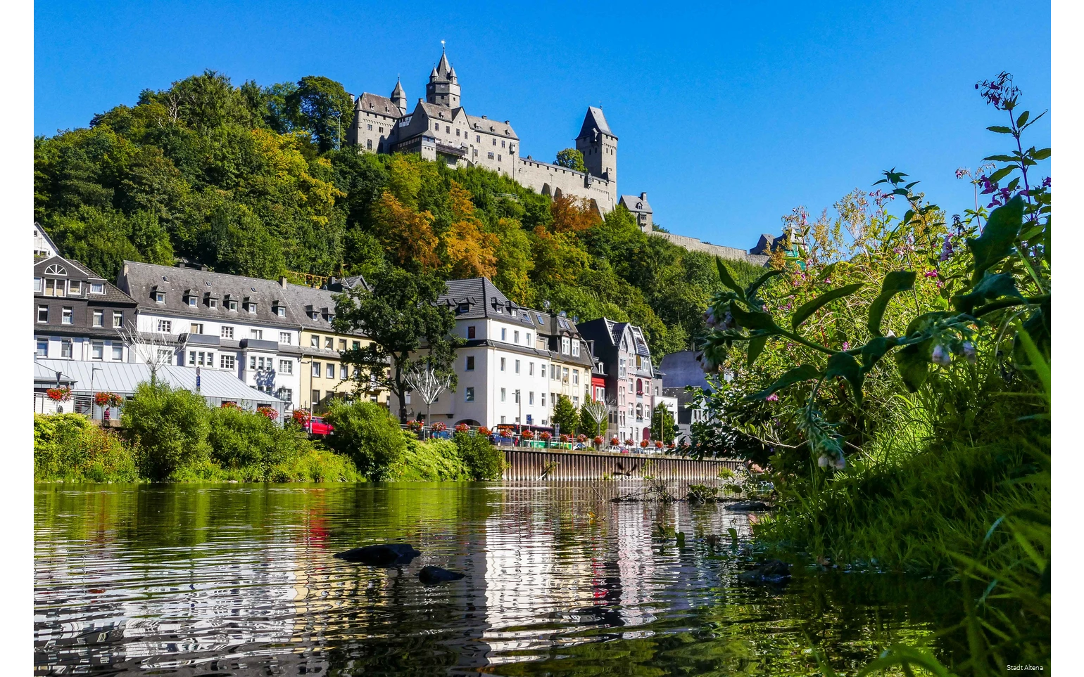 Die Lenne in Altena mit Häusern und Burg im Hintergrund