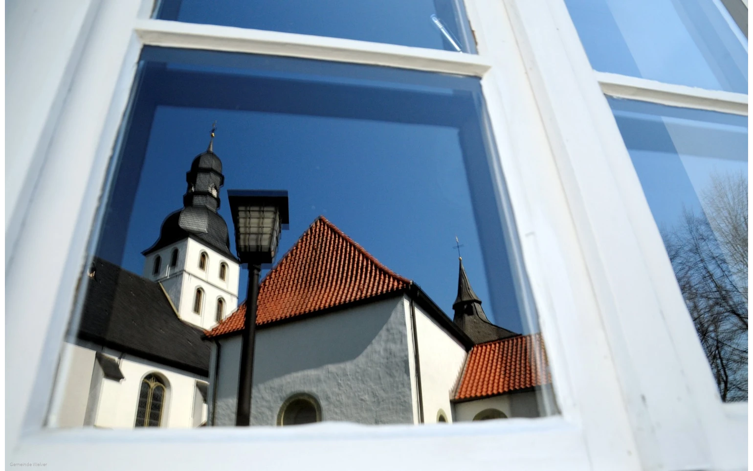 Reflectie van de kerktoren in het raam