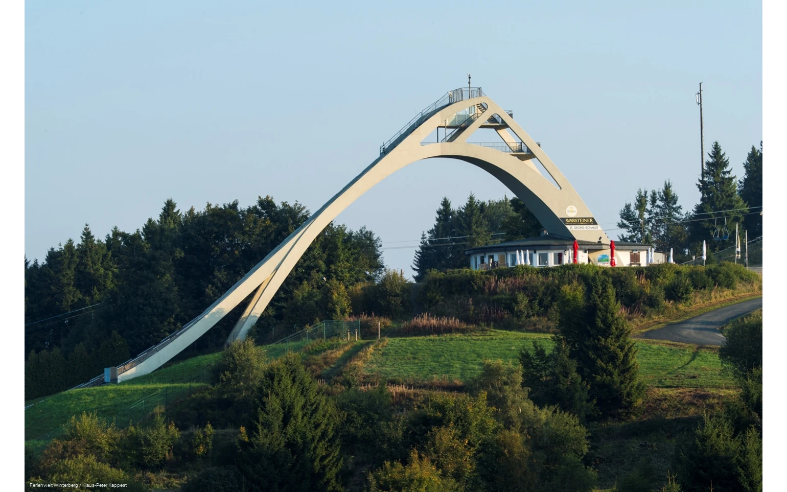 Die St. Georg Sprungschanze umgeben von Wiesen und Wäldern.