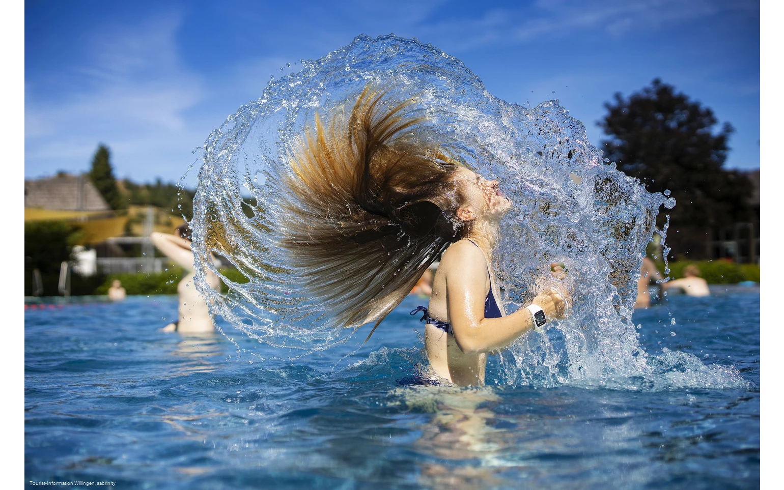 Mädchen schüttelt Wasser aus den Haaren im Freibad Usseln