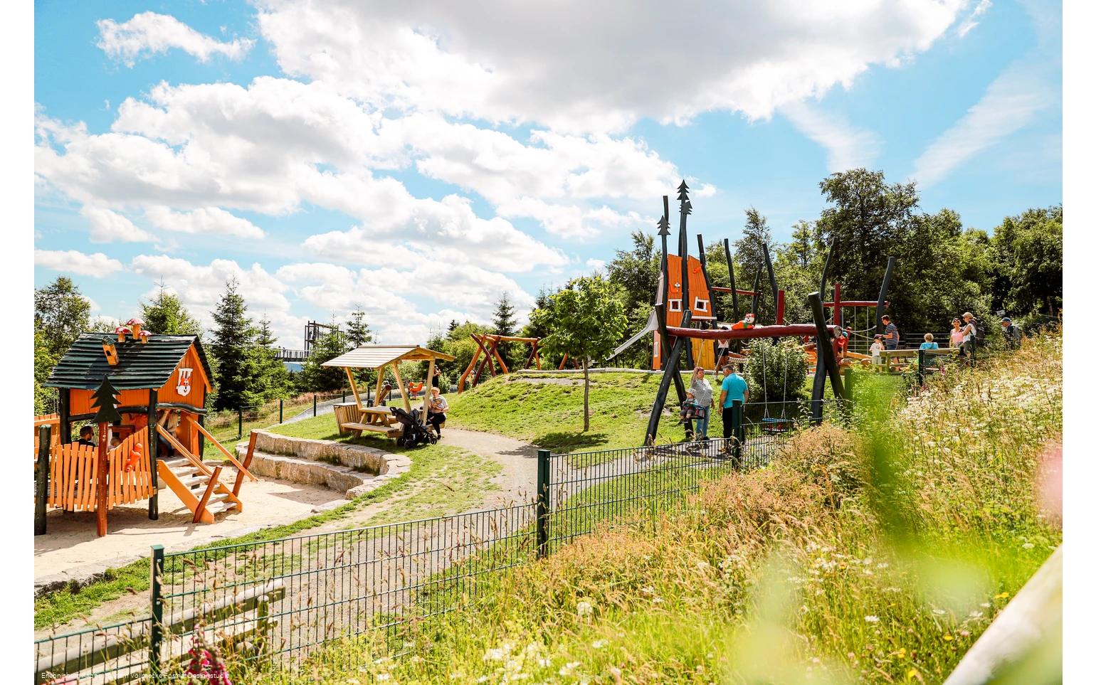 Spielplatz mit Schaukel, Rutsche und Klettergerüst.