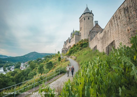 zwei Wanderer gehen unterhalb der Burg Altena