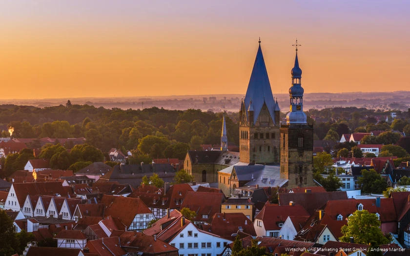 Luftaufnahme von Soest mit Kirche in der Mitte und orangem Sonnenuntergangshimmel