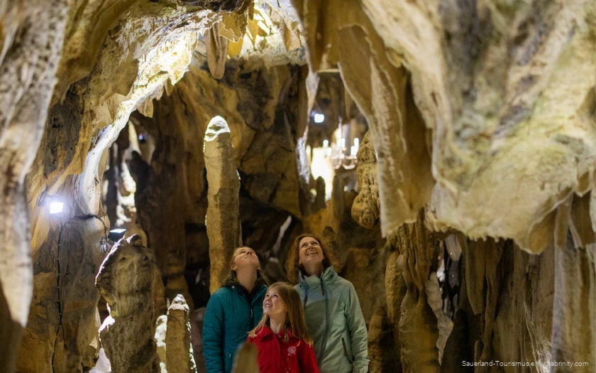 Familie besichtigt eine Höhle im Sauerland