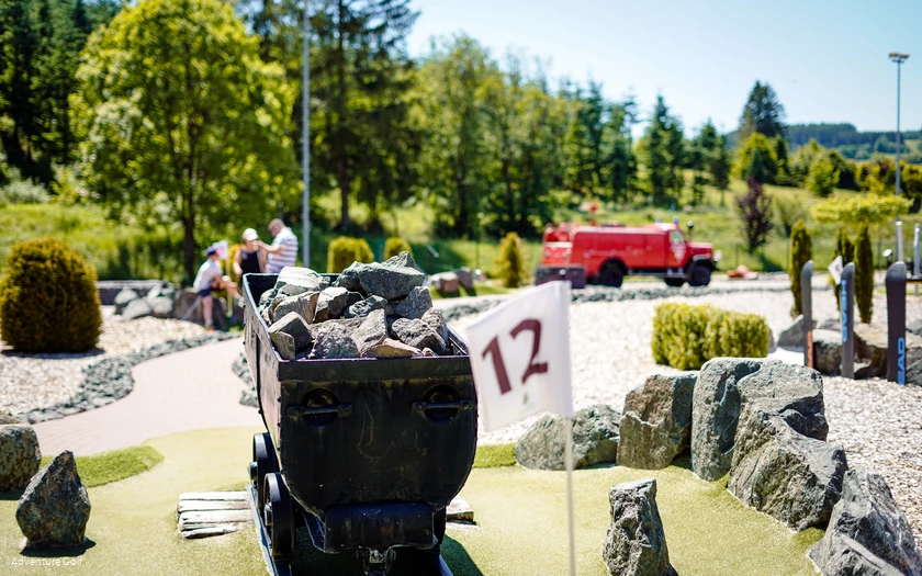 Eine Golfbahn mit einem Bergwerk-Waggon als Hindernis.