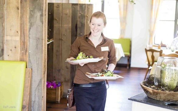 Waitress serving salads at Steinberg's Wildewiese.