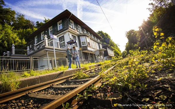 Twee vrouwen staan op het station van Dechenhöhle.
