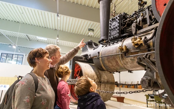 Vierköpfige Familie bestaunt alte Dampfmaschine im DampfLandLeute Museum in Eslohe.