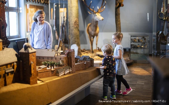 Een moeder verkent met haar kinderen het Zuid-Sauerland Museum in Attendorn.