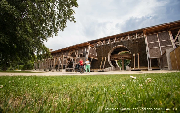 Two cyclists in front of the Gradierwerk in Bad Sassendorf.