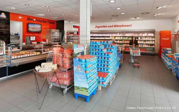 Inzicht in de verkoopruimte van de factory outlet met veel blikken worst en een toonbank voor vers voedsel