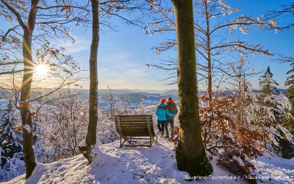 Ein Paar genießt die Wintersonne im Schnee.