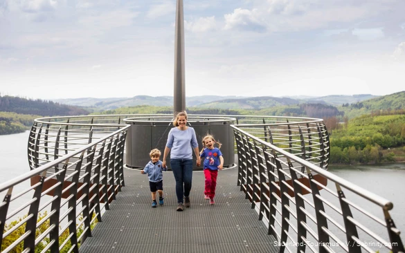 Mother with two children by the hand walking along the Skywalk Biggeblick.