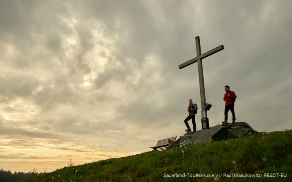 Twee wandelaars genieten van de zonsondergang op de Clemensberg.