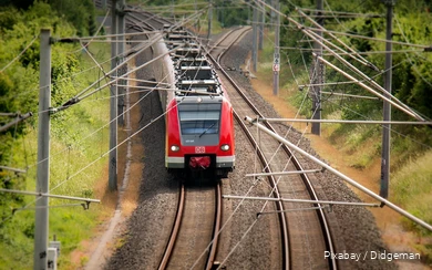 Ein Zug der Deutschen Bahn fährt durch die Landschaft.