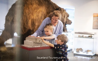 Een moeder verkent met haar kinderen het Zuid-Sauerland Museum in Attendorn.