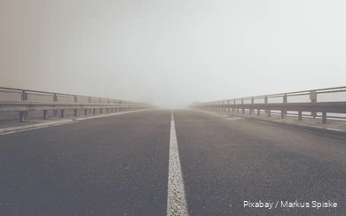 Blick auf eine Autobrücke im Nebel.