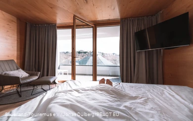 Only the feet look out of a bed with an open window