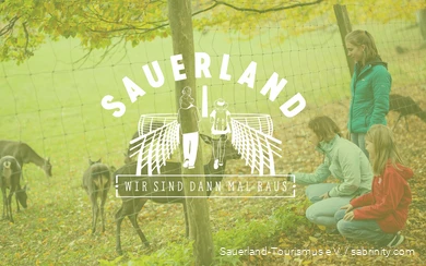 Im Hintergrund sind drei Mädchen an einem Gehege eines Tierparks. Im Vordergrund der Schriftzug "Sauerland - Wir sind dann mal raus".