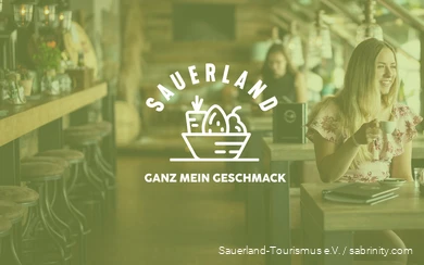 Im Hintergrund sind Frauen in einem Cafè zu sehen und im Vordergrund der Schriftzug "Sauerland - Ganz mein Geschmack".