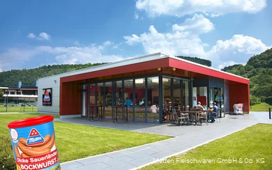 Buitenopname van de Metten factory outlet met een blikje Dicken Sauerland Bockwurst op de voorgrond