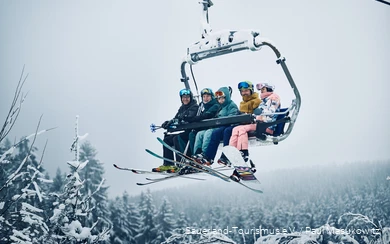 Een vrolijke groep wintersporters op de stoeltjeslift.