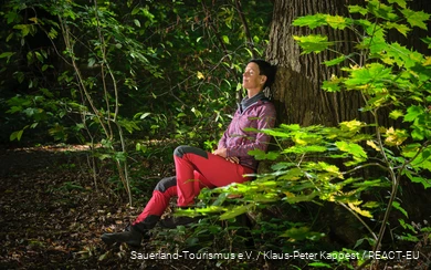 A woman enjoys nature while bathing in the forest.