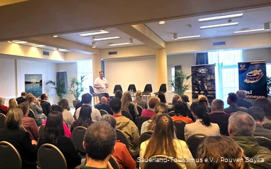 Der gefüllte Konferenzraum im Center Parcs Medebach zeigt die Teilnehmer des Tags der Ausflugsziele im Sauerland. Ein Mitarbeiter des Sauerland-Tourismus steht vorne und begrüßt die Gäste.