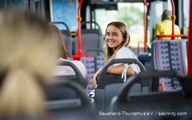 Eine Frau sitzt im Bus.