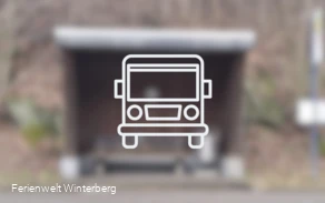 Ein verschwommenes Bild eines Bushaltestellen-Häuschens mit der Zeichnung eines Busses im Vordergrund. Dieses Bild dient als Symbolbild für Bushaltestellen.