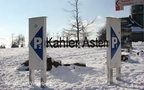 Zwei Parkplatzschilder mit der Aufschrift P1 und P2 in verschneiter Umgebung und dazwischen der Schriftzug Kahler Asten.