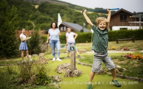 Familie macht einen Ausflug zum Minigolf im Sauerland