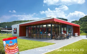 Außenaufnahme des Metten-Werksverkaufs mit Dose der Dicken Sauerländer Bockwurst im Vordergrund