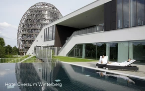 Außenansicht des Hotels Oversum mit Außenpool und Liegemöglichkeit.