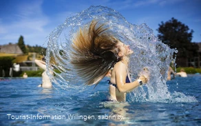 Mädchen schüttelt Wasser aus den Haaren im Freibad Usseln