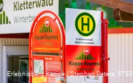 Ein Haltestellenschild mit der Aufschrift Kappe Express Winterberg und einem Fahrplan.